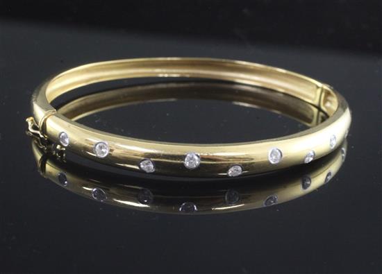 A modern 18ct gold and gypsy set diamond hinged bangle,